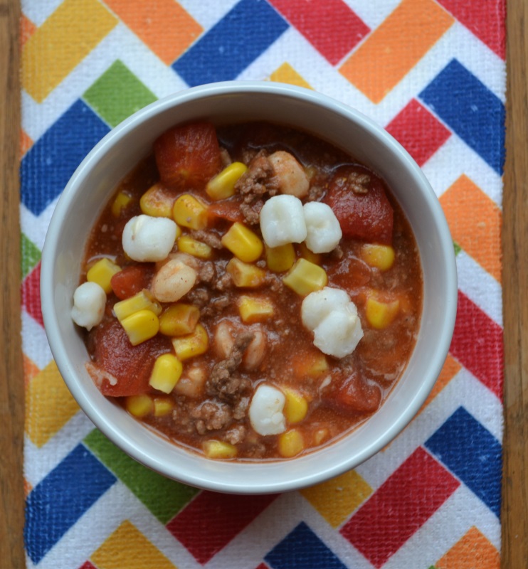 No Bean Chili in white bowl with mutli colored table cloth. Easy to make chili from www.ApronFreeCooking.com