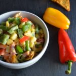 Nacho Corn Salad in a white bowl with red and yellow peppers from www.ApronFreeCooking.com