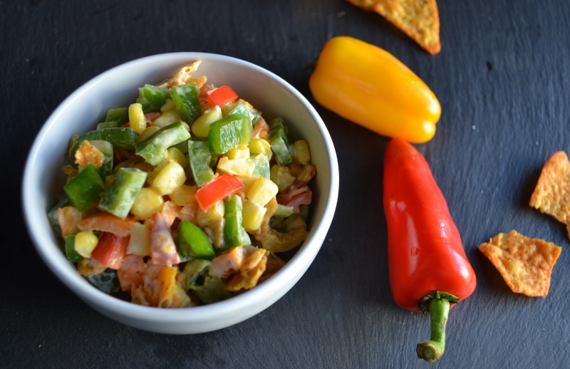Nacho Corn Salad in a white bowl with red and yellow peppers from www.ApronFreeCooking.com