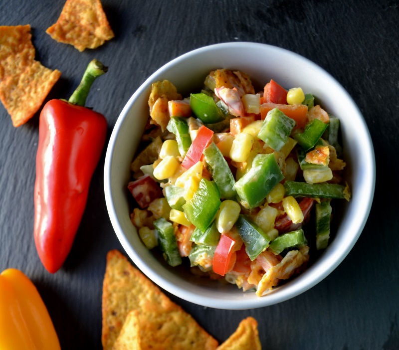 Nacho Corn Salad in a white bowl with red and yellow peppers from www.ApronFreeCooking.com