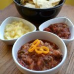 Fruity Spicy Pineapple Salsa with nachos in bowls.