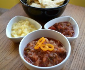 Fruity Spicy Pineapple Salsa with nachos in bowls.