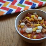 No Bean Chili in white bowl with mutli colored table cloth. Easy to make chili from www.ApronFreeCooking.com