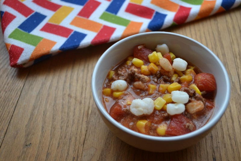 No Bean Chili in white bowl with mutli colored table cloth. Easy to make chili from www.ApronFreeCooking.com