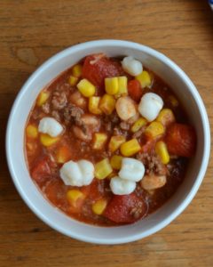 No Bean Chili in white bowl with mutli colored table cloth. Easy to make chili from www.ApronFreeCooking.com