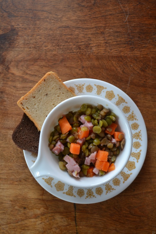 Split pea soup with carrots in bowl on wood background is an economical meal from www.ApronFreeCooking.com