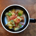 Potato soup in black mug on wooden table from www.ApronFreeCooking.com