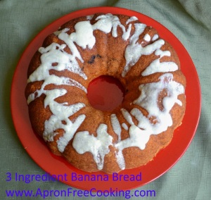 3 Ingredient Banana Bread covered with white icing drizzle over the edges on a red plate. 