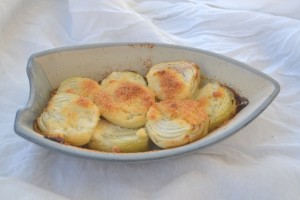 Parmesan Roasted Onions in a row boat ceramic bowl. 