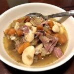 Bowl of Ham Bean soup with carrots and celery