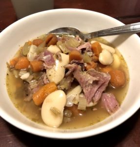 Bowl of Ham Bean soup with carrots and celery
