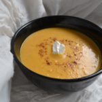 Savory Sweet Potato Soup in black bowl on white tablecloth. www.ArponFreeCooking.com