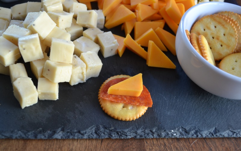 Meat and Cheese Snack Board with three kinds of cheese with close up of cheese and pepperoni on a cracker. from www.ApronFreeCooking.com