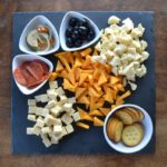 Meat and Cheese Board on gray slate with white bowls for olives and pepperoni. from www.ApronFreeCooking.com