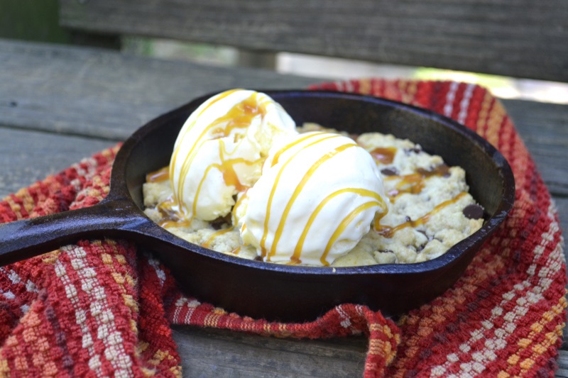 Chocolate Chip Skillet Cookie served with vanilla ice cream and caramel sauce in cast iron skillet from www.ApronFreeCooking.com