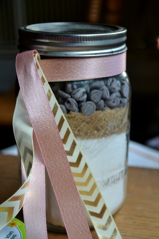 Jar of dry ingredients for Mason Jar Chocolate Chips Galore cookies from www.ApronFreeCooking.com