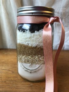 Cookie ingredients layered in a Mason jar. Coconut Raisin Mason Jar Cookie mix makes a great gift item! from www.ApronFreeCooking.com