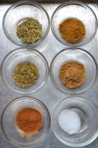 Mediterranean Spices measured into glass bowls on a metal gray background from www.ApronFreeCooking.com