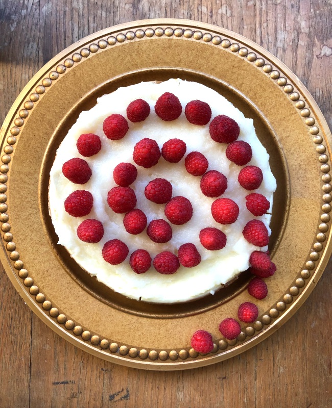 White Chocolate Raspberry Cheesecake. Berries decorate the top of cheesecake in a swirl pattern from www.ApronFreeCooking.com