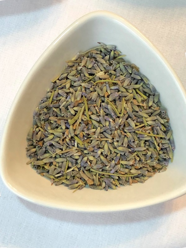 Dried lavender flower buds in white triangular bowl for lavender lemon tea from www.ApronFreeCooking.com