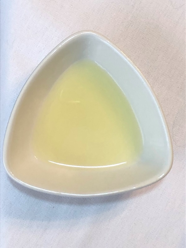 Pale yellow lemon juice in white triangular bowl from www.ApronFreeCooking.com