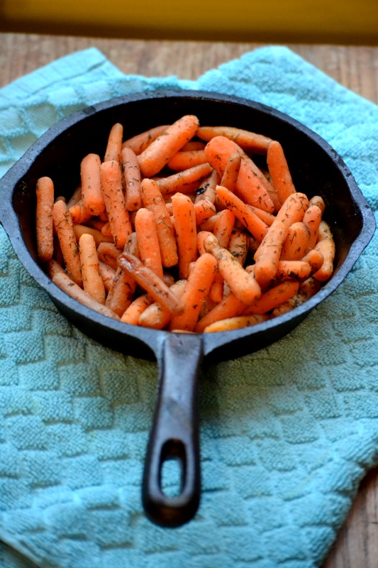 Dilly Carrots in cast iron skillet on blue towel from www.ApronFreeCooking.com