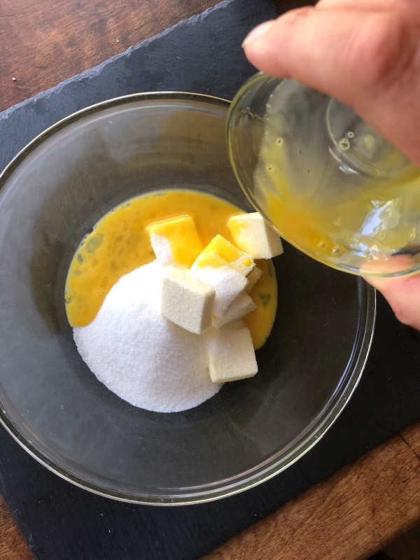 Beaten egg added to bowl with sugar and butter