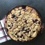 purple pie plate with blueberry buckle and crumb topping, viewed from above