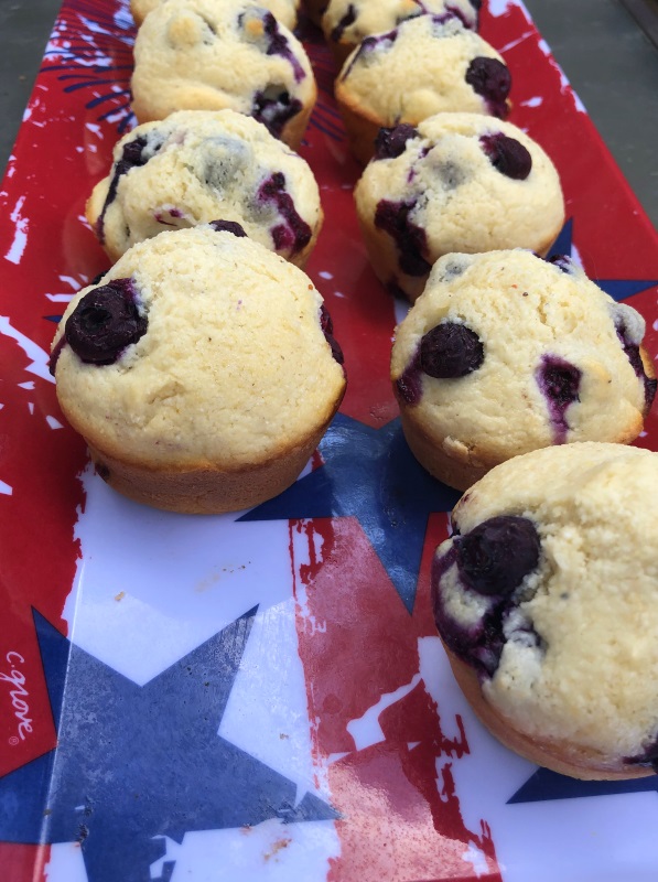 Close up view of flag printed tray with blueberry cornbread muffins in a row, but one missing