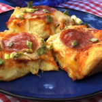 three pieces of easy biscuit pizza with pepperoni on a blue plate