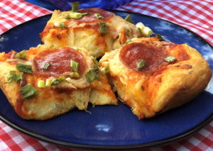 three pieces of easy biscuit pizza with pepperoni on a blue plate