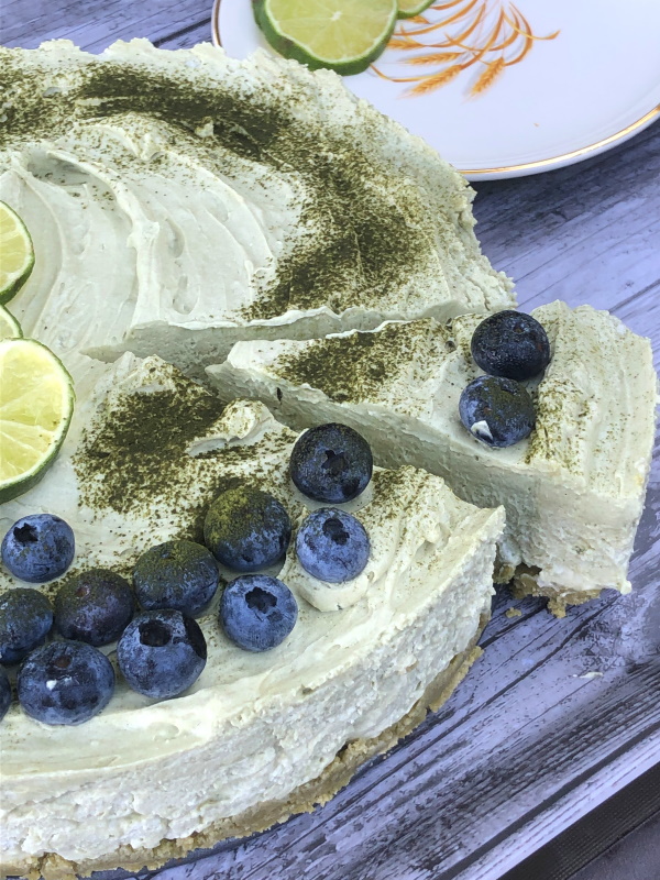 Slice of matcha no bake cheesecake being served 