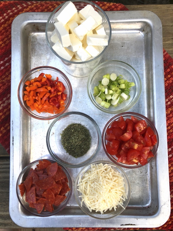 Pizza dip ingredients gathered on baking sheet